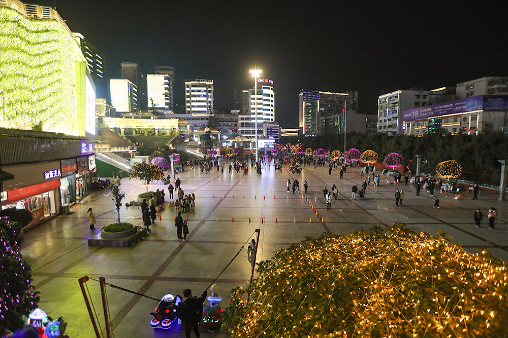 夜晚城市廣場(chǎng)，燈火璀璨，人流如織